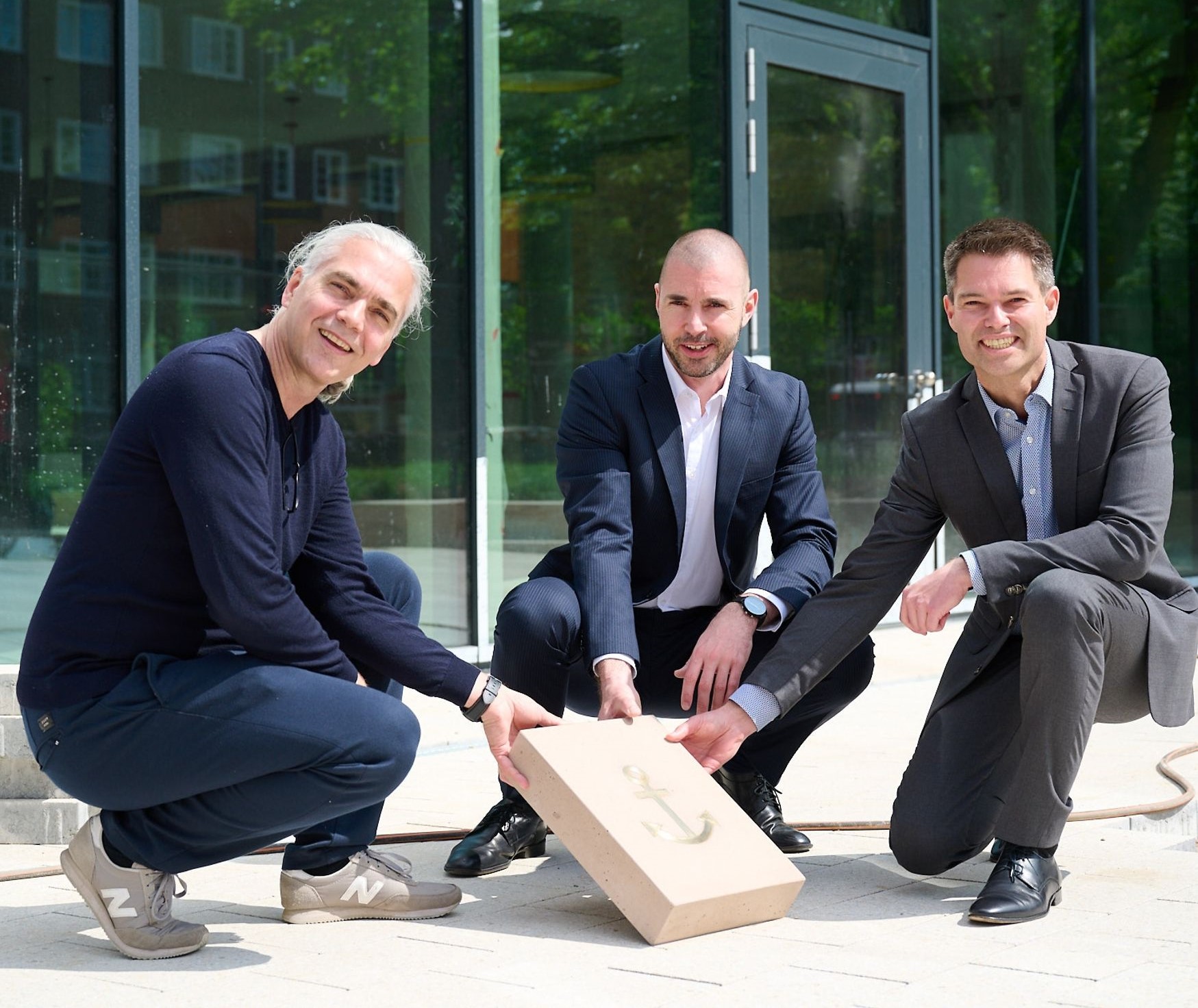 The directors of the SOS Children's Village and SSW hold the stone of SSW-Trading, which will be placed on the Walk of Help, as a sign of support for the opening of the " Harbor for Families".